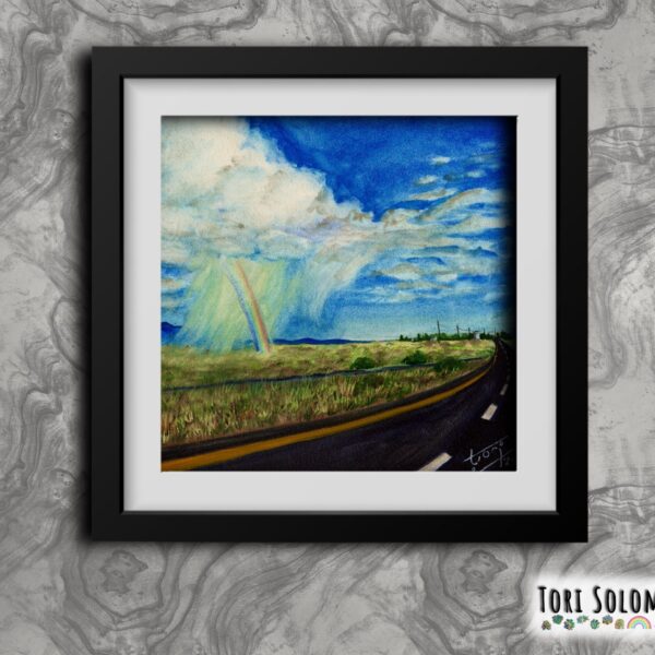 A framed colorful watercolor painting of a promise of rain and a rainbow in the distance on the New Mexican horizon