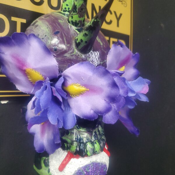 3D-Printed Skull with punk horns, purple flowers embedded into the eye sockets, and a sculpted eyeball between the skull's teeth.